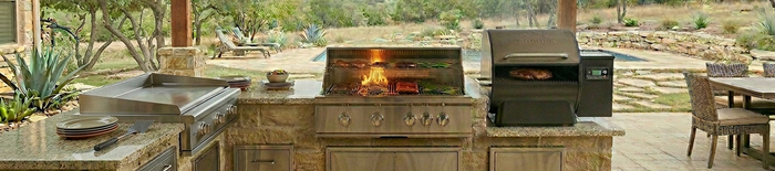 Outdoor kitchen with grill, pellet smoker, and griddle on a covered patio for Texas Grill Depot